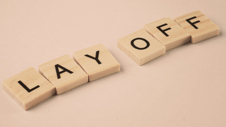Word of Lay Off. Text written by wood toy or wood cubes on white paper background with texture. Top...