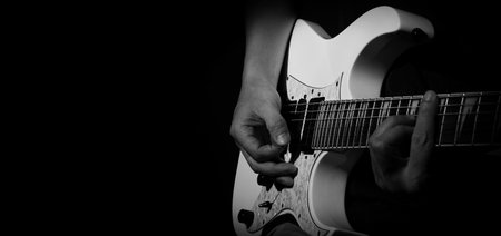 Guitarist Playing Guitar In Studio. Low key of man hand play white electric guitar for songs and...
