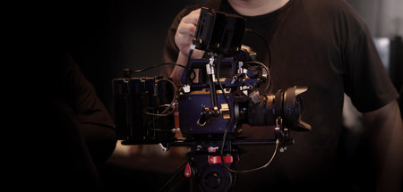 Film or video production setup with high end professional cinema cameras lighting camera rig and crew members working on set. Behind the scenes or BTS video shoot in a studio for cinematic visuals.の写真素材