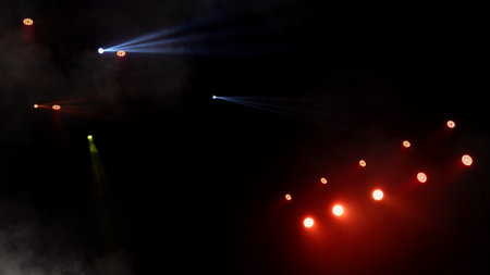 Stage lights background. Light beams and smoke from the stage spotlights on the stage at time of show. Laser show isolated on black background. Empty stage with light projector illumination backdrop.の写真素材