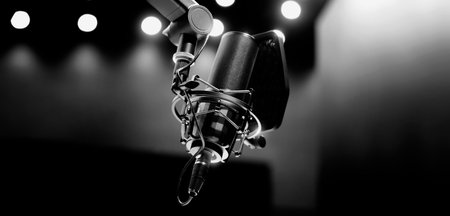 Microphone in studio. Professional studio microphone with a pop filter is suspended boom arm and studio lights. Set up mic for podcast voice over or recording high quality sound audio in a controlled.の写真素材