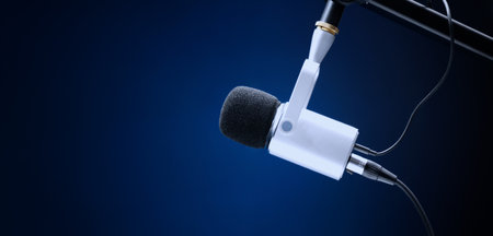 Microphone in studio. Professional studio microphone with a pop filter is suspended boom arm and studio lights. Set up mic for podcast voice over or recording high quality sound audio in a controlled.の写真素材