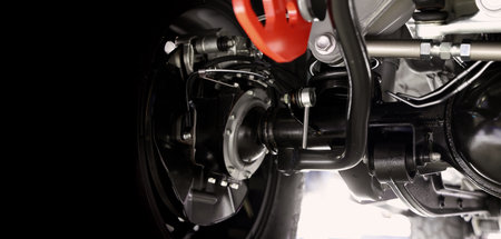 Car suspension part. Close up of a rear car suspension and exhaust system. such as coil springs link arms axle housing and performance exhaust. For auto engineering or car suspension part industry useの写真素材