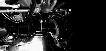Car suspension part. Close up of a rear car suspension and exhaust system. such as coil springs link...