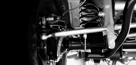 Car suspension part. Close up of a rear car suspension and exhaust system. such as coil springs link arms axle housing and performance exhaust. For auto engineering or car suspension part industry useの写真素材