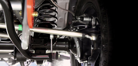 Car suspension part. Close up of a rear car suspension and exhaust system. such as coil springs link arms axle housing and performance exhaust. For auto engineering or car suspension part industry useの写真素材