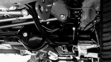 Car suspension part. Close up of a rear car suspension and exhaust system. such as coil springs link arms axle housing and performance exhaust. For auto engineering or car suspension part industry useの写真素材