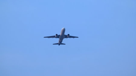 Airplane in the sky. Airplane in flight at sunset or evening sky. Commercial airliner silhouette in the colorful evening or night moon skies. Aircraft symbol of travel adventure global connectivity.の写真素材
