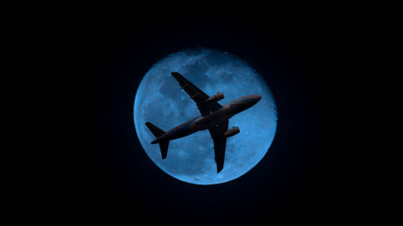 Airplane in the sky. Airplane in flight at sunset or evening sky. Commercial airliner silhouette in the colorful evening or night moon skies. Aircraft symbol of travel adventure global connectivity.の写真素材