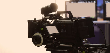 Behind the scenes of movie shooting or filming or video production with high quality camera and tripod equipment set up and professional film crew team in studio lighting. Video production camera gearの写真素材