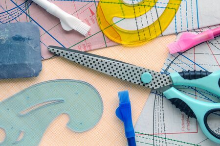 Sewing kit on the background of the pattern. Colorful set consisting of scissors, cutterâs rulers, pencils and textile soap.の写真素材