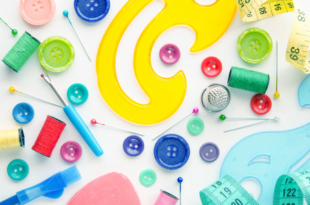 Sewing kit on the white background. Colorful set consisting of measuring tape, ruler, pins, buttons, bobbins, pencils.の写真素材