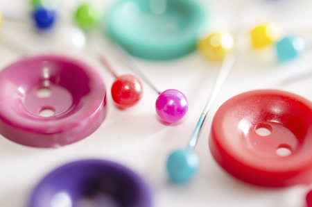 Sewing set on the white background. Macro shot. Colorful sewing kit consisting of pins and buttons.の写真素材