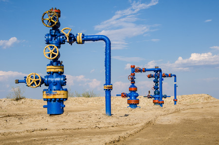 Group of wellheads. Oilfield with sand ground. Oil and gas concept.の写真素材