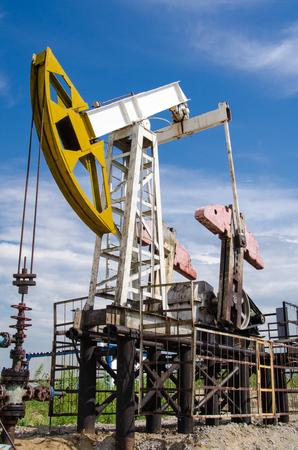 Pump jack and wellhead in the oilfield. Oil and gas concept.の写真素材