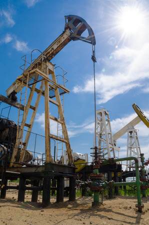 Pump jack and wellhead in the oilfield. Oil and gas concept.の写真素材