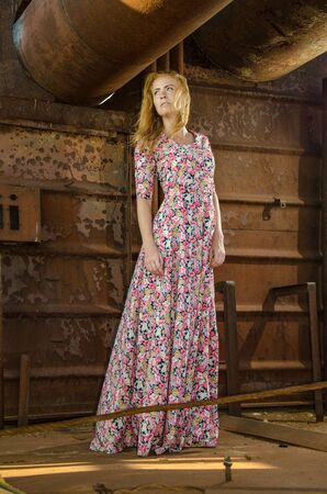Young beautiful girl wearing long dress on the the background of old ship.の写真素材
