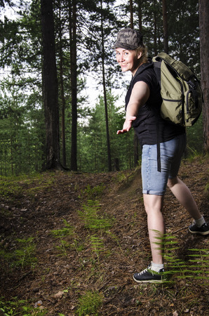 Beautiful girl traveling in the forest with backpack. Adventure, travel, tourism, hike concept.の写真素材