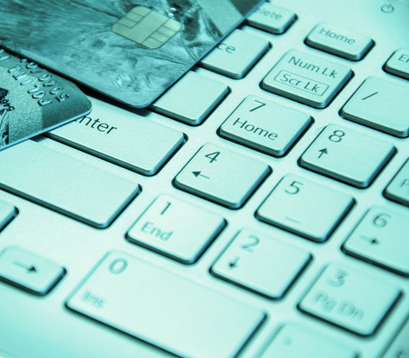 Credit cards on a laptop keyboard. On line shopping, e-commerce and internet purchase concept. Selective focus. Toned.の写真素材