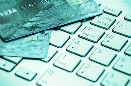 Credit cards on a laptop keyboard. On line shopping, e-commerce and internet purchase concept. Selective focus.の写真素材