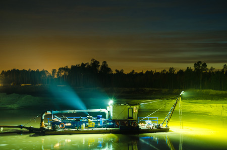 Dredger boat working in the lake during sunset. Toned.の写真素材
