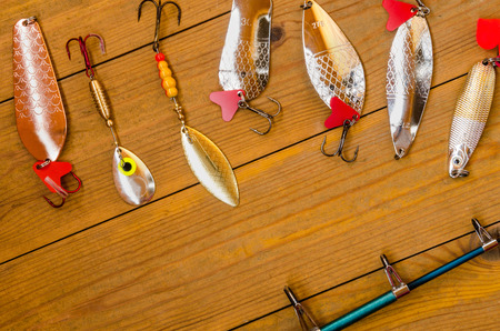Fishing accessories for summer consisting of tackle, bait, lure, jig, hook, net. Wooden background....