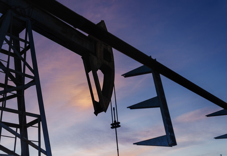 Oil pump and pipeline silhouette during sunset at the oilfield. Oil and gas concept.の写真素材