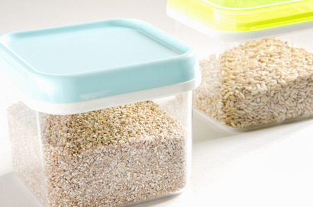 Food storage. Food ingredients (cut wheat and wild rice) in plastic containers. Selective focus. の写真素材