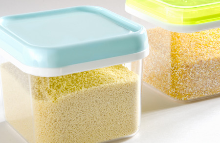 Food storage. Food ingredients (cous cous and polenta) in plastic containers. Selective focus.の写真素材