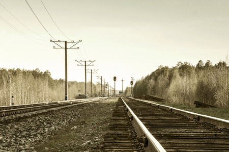 Modern electificated railroad track close to vintage one with wooden sleepers. Toned. の写真素材