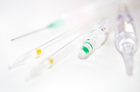 Medical syringe for injection and ampules on a white background. Selective focus.の写真素材