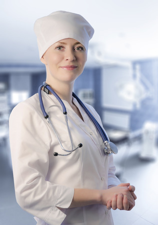 Young woman medical doctor portrait in white coat and cap with stethoscope.の写真素材