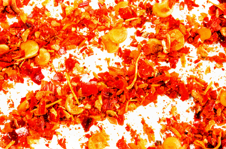 Dry crushed chili flakes isolated on white. Food background. Closeup macro shot. Top view.の写真素材