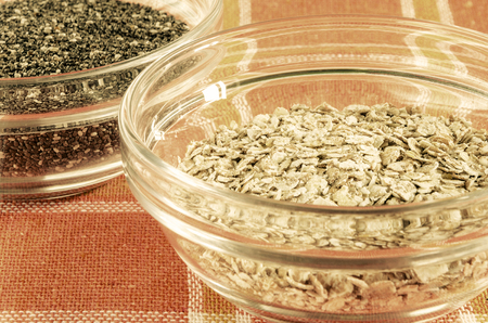 Oat flakes and chia seeds in a glass bowl on colorful dishcloth. Closeup shot. Healthy food concept. Toned.の写真素材