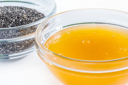 Chia seed and honey in a glass bowl isolated on white background. Closeup shot. Healthy food concept.の写真素材