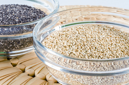 Quinoa and chia seed in a glass bowl on straw hot pad. Closeup shot. Healthy food concept.の写真素材