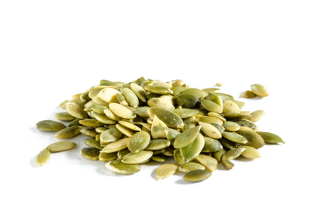 Heap of raw pumpkin seeds isolated on whiteの写真素材