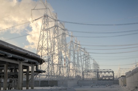 High voltage power lines in the winter. Thermal power plant with smoke from the pipes.の写真素材