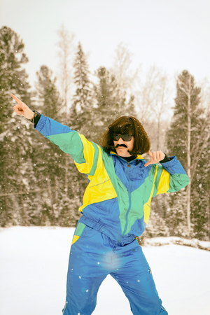 Vintage photo of young man snowboarder in the mountains. Retro style. 1980 concept.の写真素材