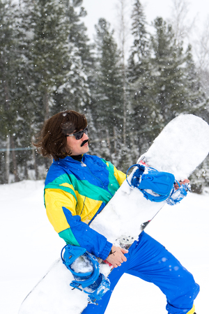 Vintage photo of young man snowboarder in the mountains. Retro style. 1980 concept.の写真素材