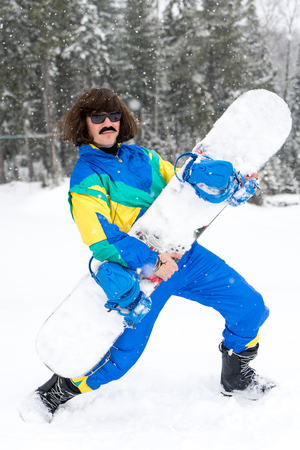 Vintage photo of young man snowboarder in the mountains. Retro style. 1980 concept.の写真素材