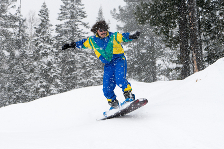 Vintage photo of young man snowboarder in the mountains. Retro style. 1980 concept.の写真素材