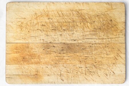 Old and used natural wooden cooking board with cutsの写真素材