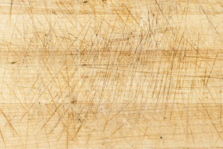 Old and used natural wooden cooking board with cutsの写真素材