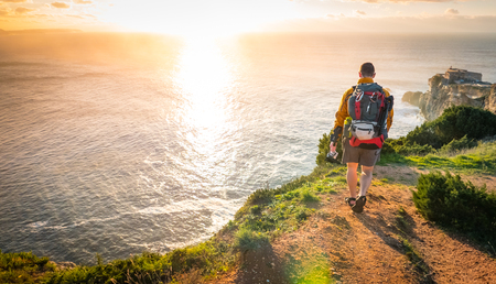 Young adult caucasian man walking along the seascapeの写真素材