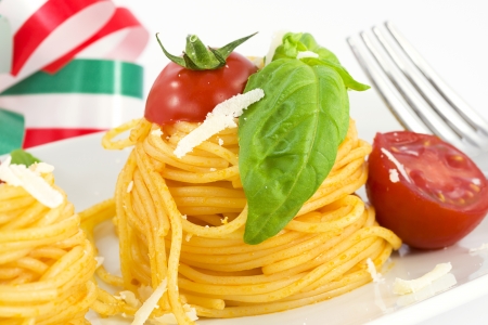 nests of spaghetti with tomato, basil and parmesanの写真素材