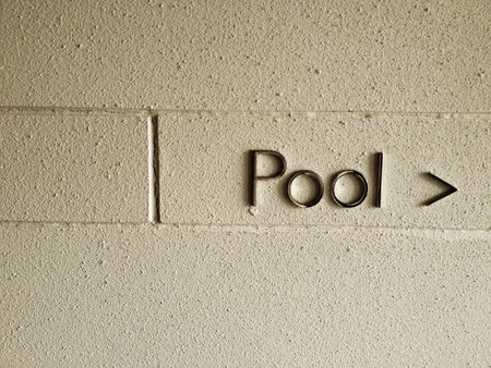 a sign on a wall showing the direction to pool