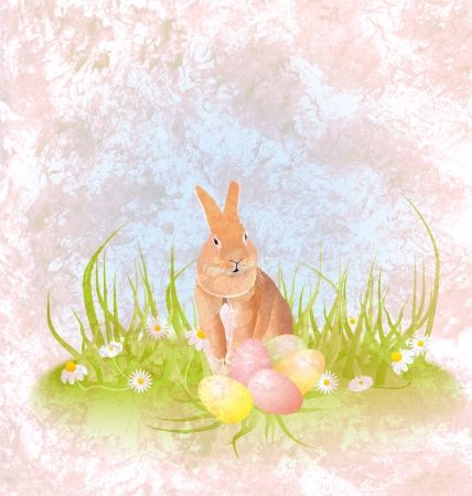 brown hare or rabbit sitting in the grass with easter eggs and daisies grungeの写真素材