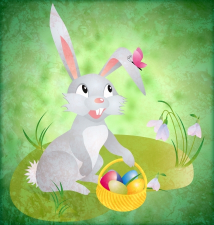 easter bunny with busket and eggs on green grunge backdrop with grass and flowersの写真素材