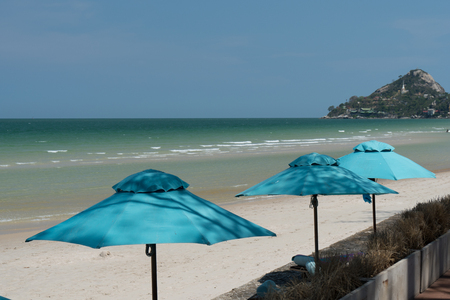Blue umbrellas on the beach and sea. Sea, beach, blue sky background.の写真素材